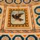 ...chiudono al centro la raffigurazione di un’aquila nera con una freccia dorata tra gli artigli
